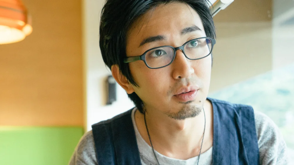 話を真剣に聞く顎髭を生やしたメガネをかけた男性