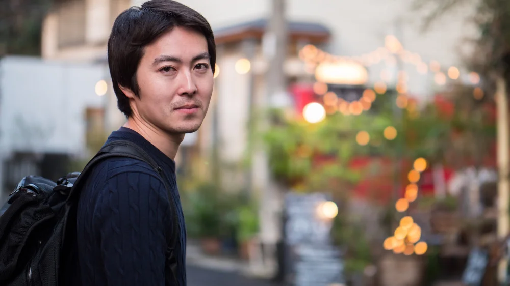 黒いリュックを背負った黒い洋服の男性