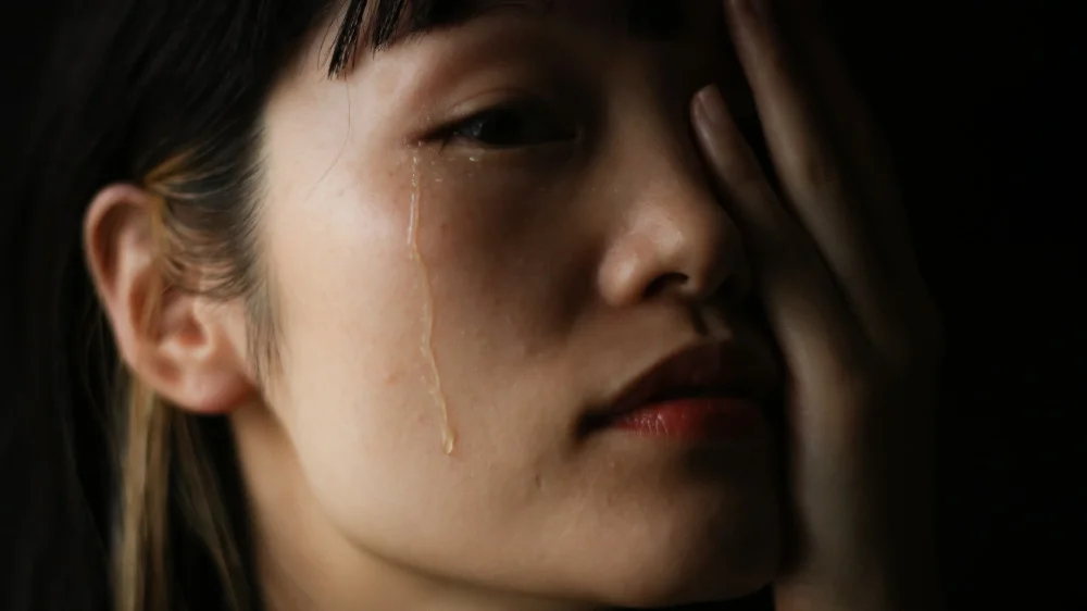 右目の目頭から涙を流している女性