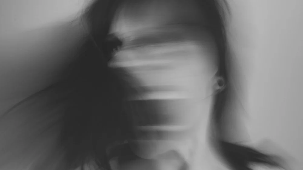 叫びながら顔を左右に大きく振る女性