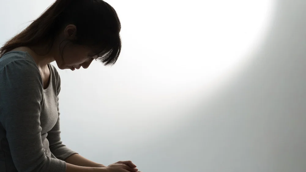 下を向きながら落ち込んでいる女性